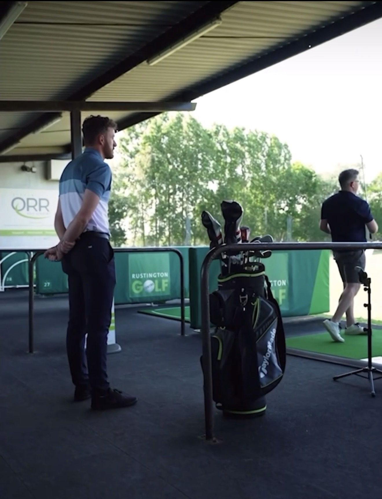 Jake Dunstan reviewing swing data with a student
